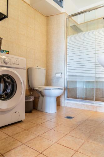 a bathroom with a toilet and a washing machine at Nenes House in Koroni