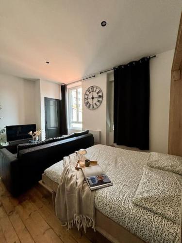 une chambre avec un lit et une horloge au mur dans l'établissement Studio centre ville, cosy, neuf 204, à Saint-Étienne
