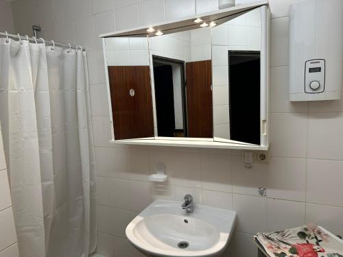 a bathroom with a sink and a mirror at Ferienwohnung Dreiländerblick in Perl