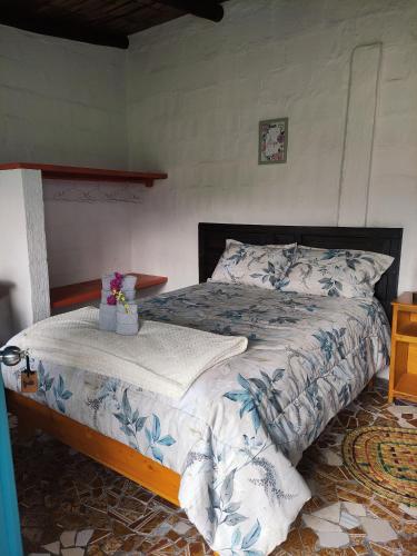 a bedroom with a bed with a blue and white comforter at Finca San Alejandro in Cotacachi