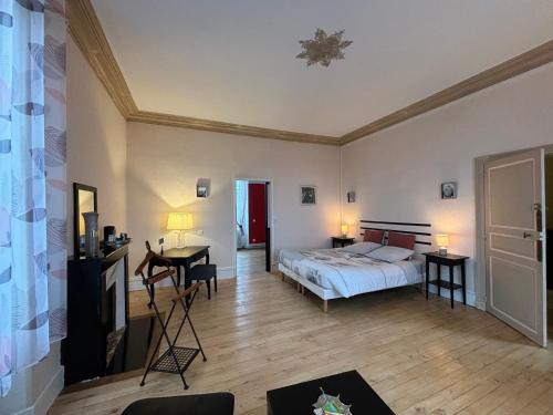 une chambre avec un lit, une table et des chaises dans l'établissement Chambres d'hôtes, parc, dîner dispo - FR-1-591-701, à Le Blanc