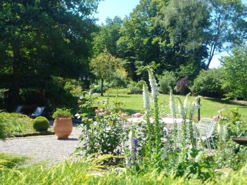 a garden with a vase and flowers in a park at Chambre d'hôtes avec salle d'eau privée dans un Prieuré historique - FR-1-589-737 in Aydoilles