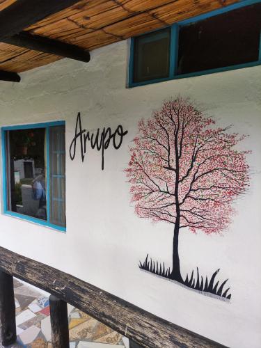 a tree painted on the side of a building at Finca San Alejandro in Cotacachi