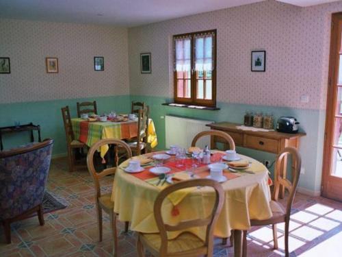 une salle à manger avec une table et des chaises et une cuisine dans l'établissement Chambres cosy au cœur de la forêt d'Argonne - FR-1-585-139, à Futeau