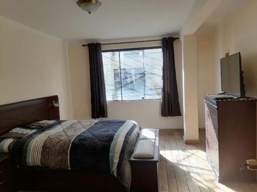 een slaapkamer met een bed en een raam bij Central Stay Departamentos in Oruro