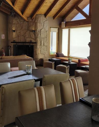 a dining room with tables and chairs and a fireplace at Galileo Boutique Hotel in San Carlos de Bariloche