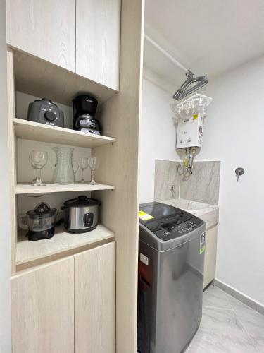 a small kitchen with a trash can in a room at Apto Centrico y Acogedor Parque principal Sabaneta in Sabaneta