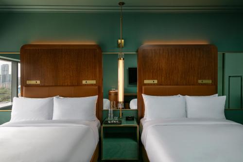 two beds in a room with green walls at W Austin in Austin