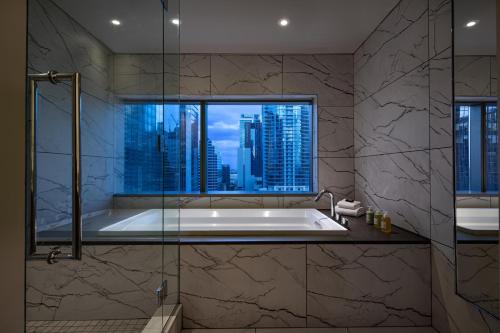 a bathroom with a bath tub with a window at W Austin in Austin