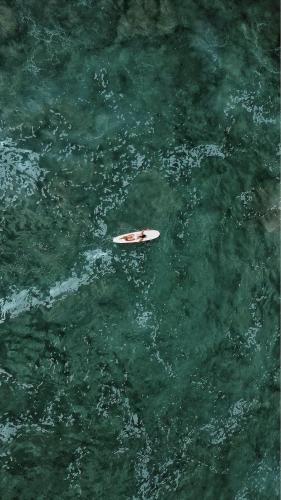 a white surfboard in the middle of the water at Buena Vista Surf Club in Playa Maderas