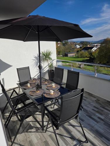 a table and chairs with an umbrella on a patio at White Luxury Villa in Haslach an der Mühl