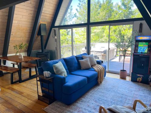 a blue couch in a living room with a video game at Hot Tub-EV-AC-Kid Friendly-Arcade Game-Lake Access in Lake Arrowhead