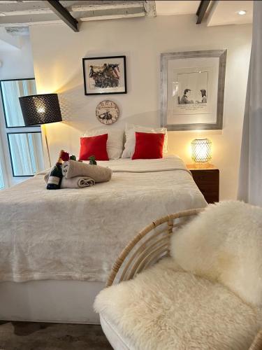 une chambre avec un grand lit blanc avec des oreillers rouges dans l'établissement Charmant studio et style unique, à Paris