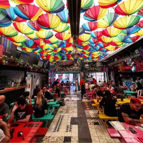 a group of people sitting in a restaurant with colorful umbrellas at Perfecta Ubicación en Ciudad de México in Mexico City