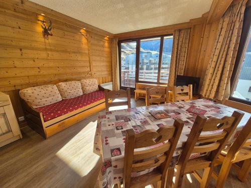 - une salle à manger avec une table et un lit dans une chambre dans l'établissement Appartement lumineux proche pistes et commerces, 3P/8 pers, balcon exposé sud - FR-1-502-363, à Tignes