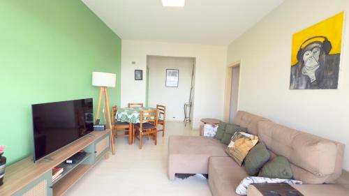 een woonkamer met een bank en een flatscreen-tv bij Curitiba Central - Apartamento completo e perto de tudo in Curitiba