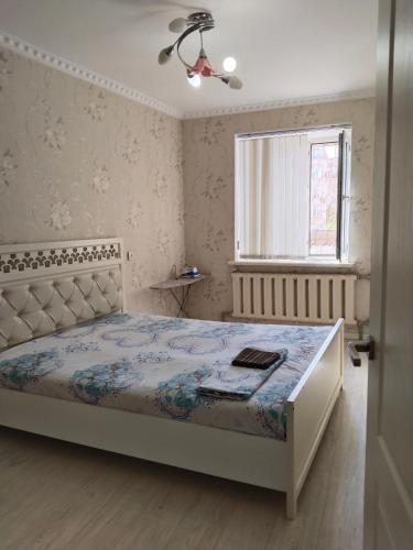 une chambre avec un lit et une fenêtre dans l'établissement Минималистичная квартира, à Kyzylorda