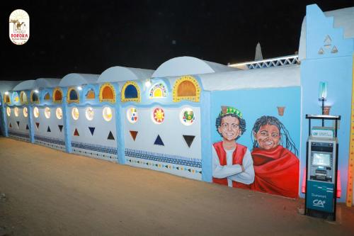 a wall with paintings of people on it at DoroKa Nubian House in Aswan