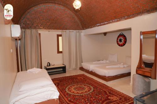 a bedroom with two beds and a mirror at DoroKa Nubian House in Aswan