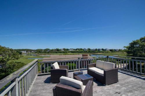 una terraza con sillas y mesas y vistas al agua en Stunning Water Views 2 Decks By Beach, en Chatham