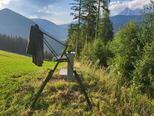 a telescope in a field with mountains in the background at Bauernhof - Appartement beim Zefferer in Schladming