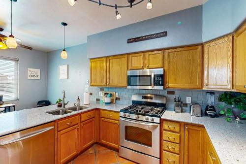 a kitchen with wooden cabinets and a stove top oven at Spearhead Serenity in Tucson