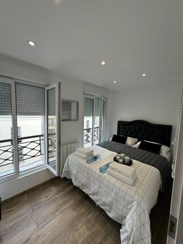 une chambre avec un lit et une grande fenêtre dans l'établissement Appartement de Brigitte, à Paris