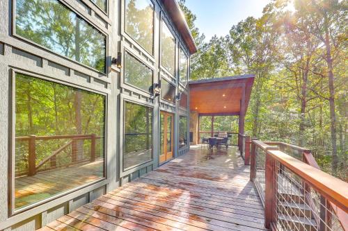 a large house with a deck with windows at Cozy Secluded Cabin in the Heart of Hochatown in Stephens Gap