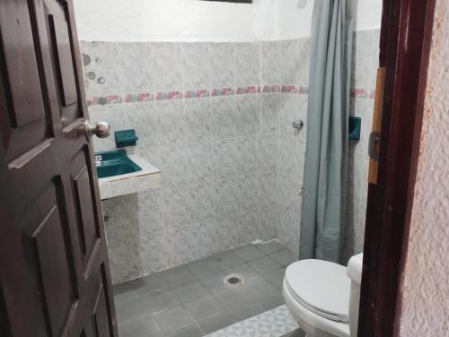 a bathroom with a toilet and a sink at Casa de huespedes LOS SANTOS in Cancún