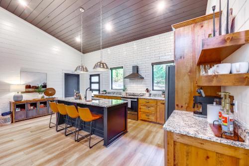 a large kitchen with a large island with bar stools at Cozy Secluded Cabin in the Heart of Hochatown in Stephens Gap