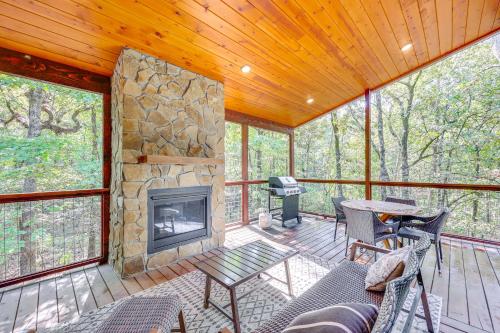 a screened in porch with a fireplace and a table and chairs at Cozy Secluded Cabin in the Heart of Hochatown in Stephens Gap
