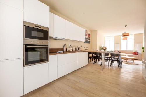 une cuisine avec des placards blancs et une salle à manger dans l'établissement Standing 4 chambres et 4 salles de bains face marché de Wazemmes Lille, à Lille