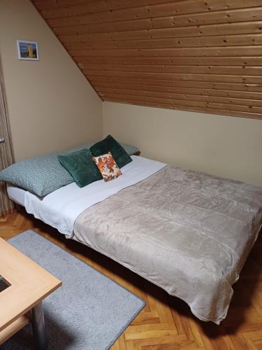 a bed in a room with a wooden ceiling at HutiFeri apartman in Siófok