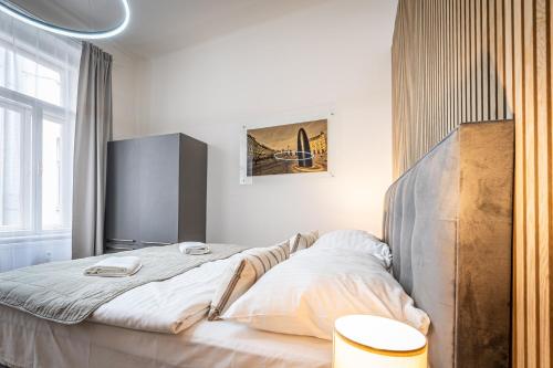 a bedroom with a large bed with a wooden headboard at Apartmánový Dům Centrum in Brno