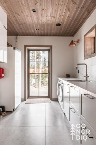 a kitchen with a washer and dryer and a window at The Reindeer Lodge including guesthouse in Tällberg