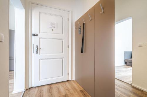 a white door in a room with a hallway at Apartmánový Dům Centrum in Brno