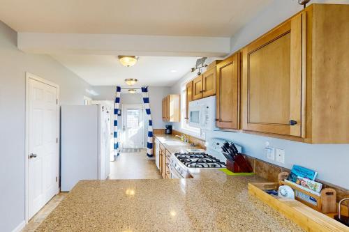 a kitchen with wooden cabinets and a white refrigerator at 3 Bed 2 Bath Vacation home in Newport in Newport