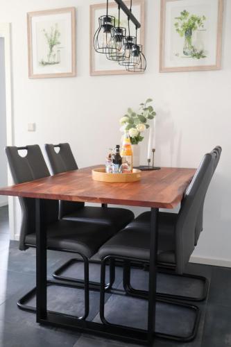 a dining room table with black chairs around it at Die Idyllische - Ferienwohnung mit Garten und Sauna in Kleve