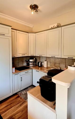 a kitchen with white cabinets and wooden floors at Beach apartment Suzy&Demi in Split