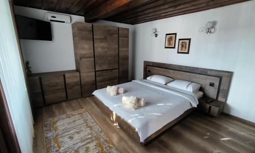 a bedroom with a large bed with white sheets and pillows at Къща за гости Етерна - Guest house Eterna in Starosel