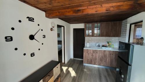 a kitchen with a clock on the wall at Къща за гости Етерна - Guest house Eterna in Starosel