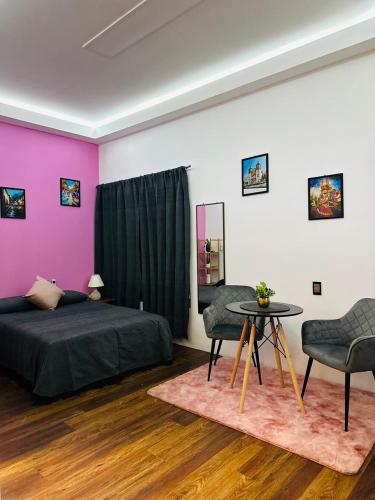 a bedroom with a bed and a table and chairs at Casa Don José TULIPANES Suite in Oaxaca City