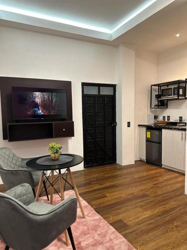 a living room with a table and chairs and a kitchen at Casa Don José TULIPANES Suite in Oaxaca City