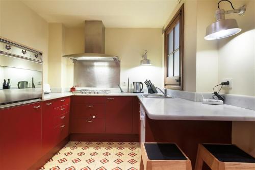 a large kitchen with red cabinets and a sink at Friendly Rentals Manel in Barcelona