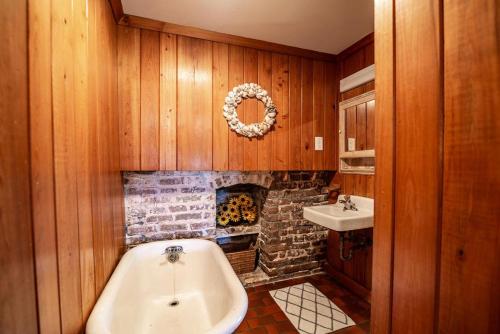 a bathroom with a fireplace and a tub and a sink at Historic Bliss on Pawleys Island's Shoreline in Pawleys Island