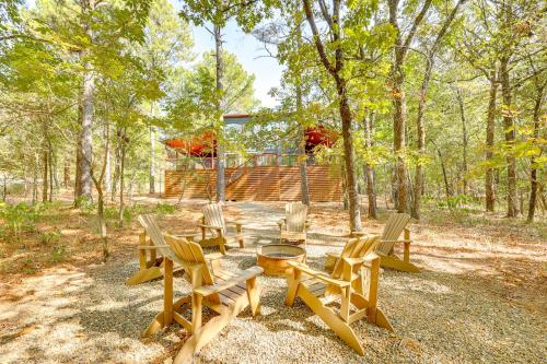 a group of chairs and a table in the woods at Cozy Secluded Cabin in the Heart of Hochatown in Stephens Gap