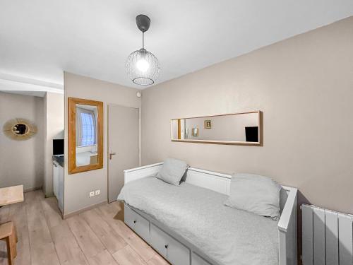 une chambre avec un lit et un miroir au mur dans l'établissement LE Cosy De La Gare, à Tours