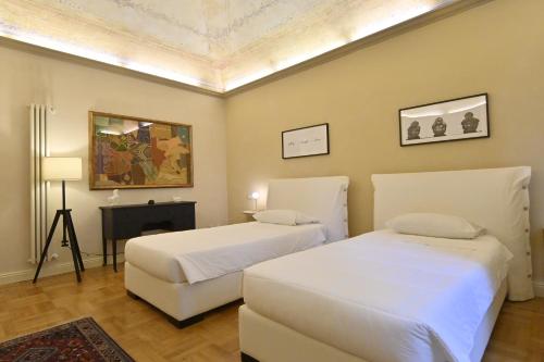 a bedroom with two beds and a fireplace at LA CASA DI MONIC in Pisa