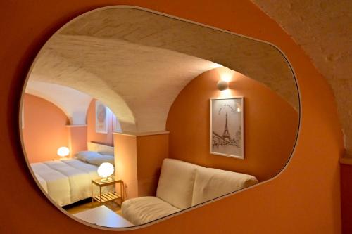 a room with a round mirror with a bed and a couch at LA CASA DI MONIC in Pisa