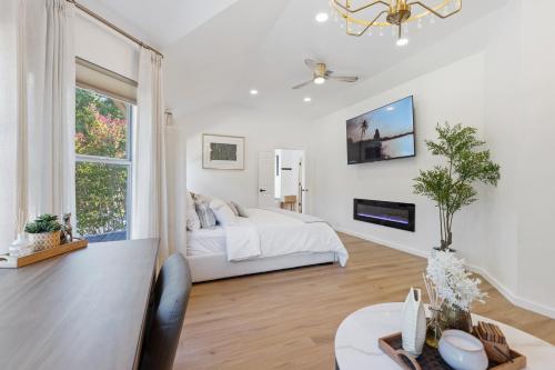 a white bedroom with a bed and a window at The staycation, 4 beds-3 baths, with pool and hot tub near AT&T stadium, 20 mins to Dallas and Fort Worth in Grand Prairie